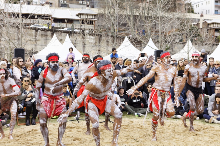Aboriginal cultural performance with dancers in traditional body paint before seated audience