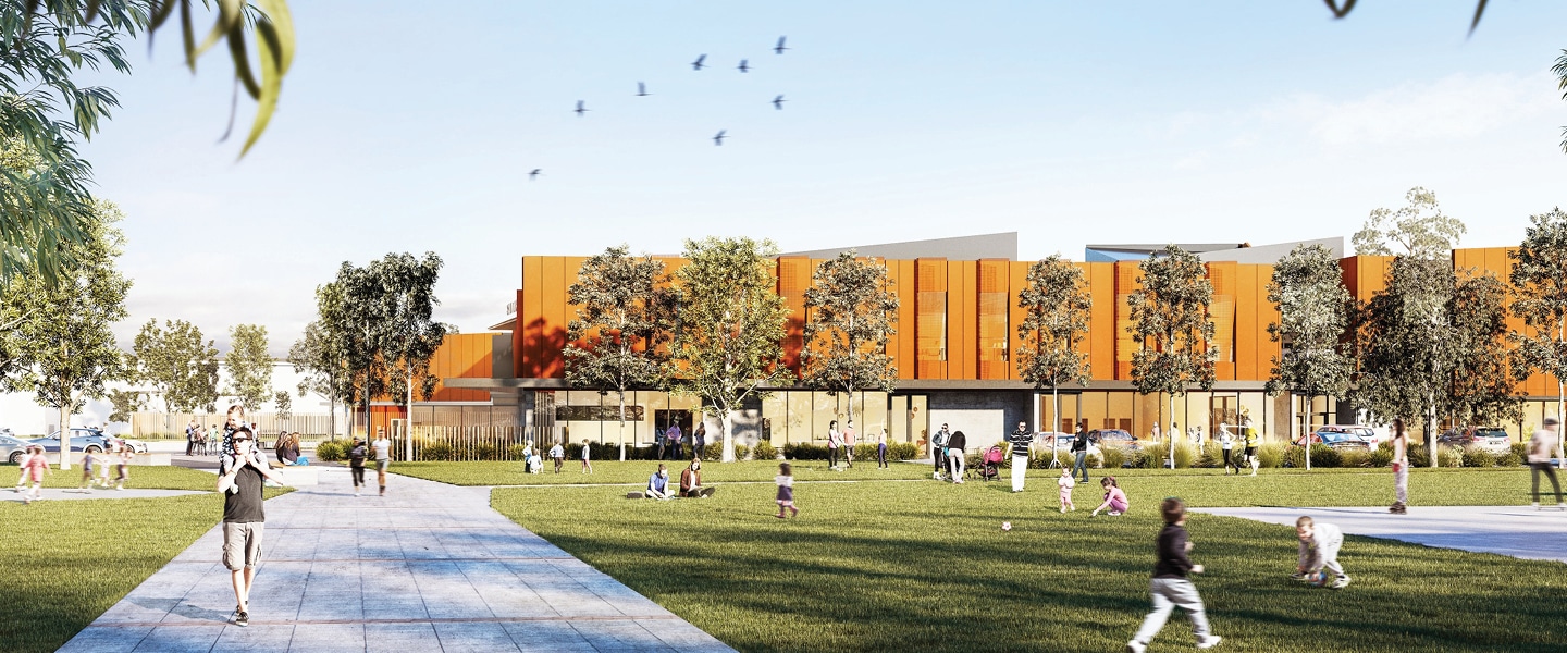 Modern building with orange cladding, landscaped frontage, and an outdoor spiral water slide under a blue sky.
